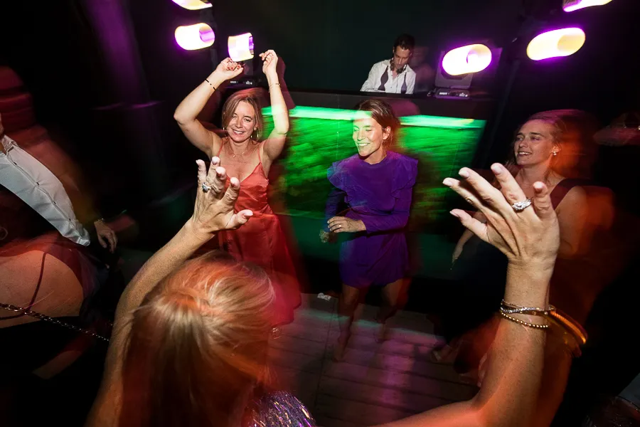 Dansende gasten in groen en paars licht