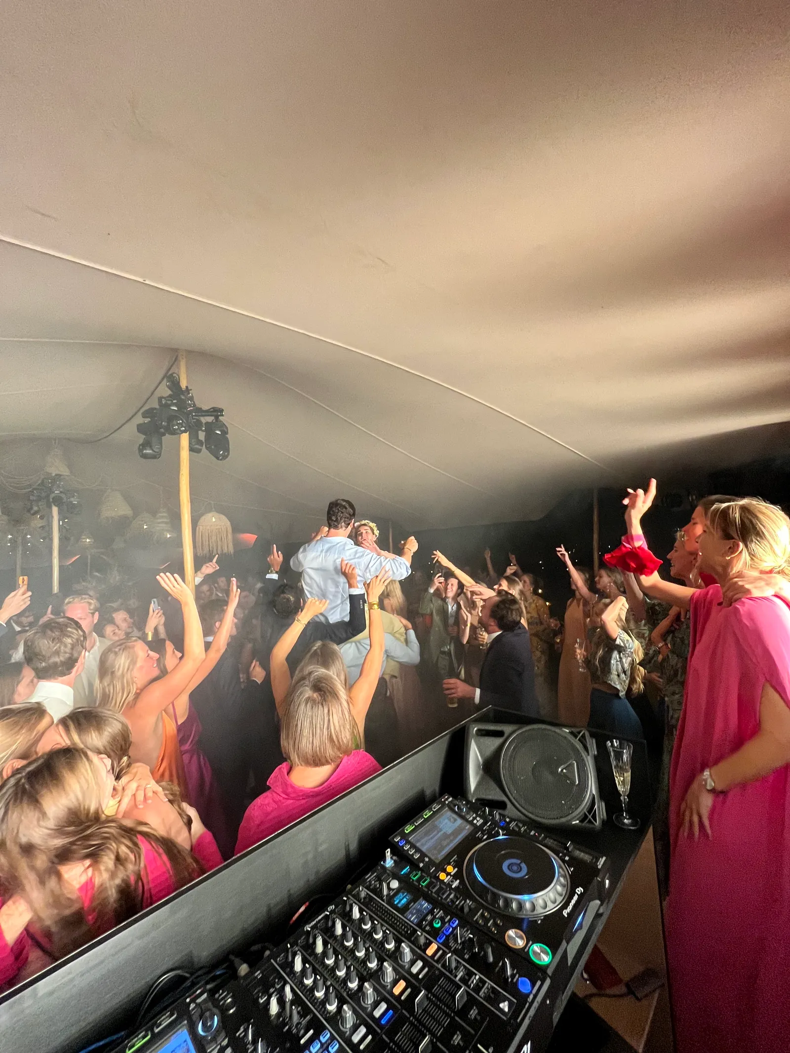 Feest in een tent, gasten dansen voor de draaitafels